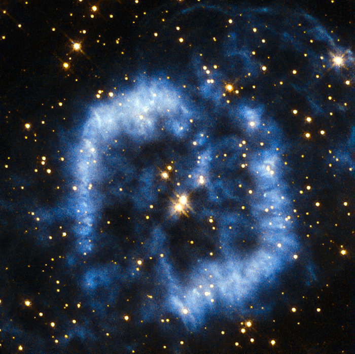 This planetary nebula is called PK 329-02.2 and is located in the constellation of Norma in the southern sky. It is also sometimes referred to as Menzel 2, or Mz 2, named after the astronomer Donald Menzel who discovered the nebula in 1922. When stars that are around the mass of the Sun reach their final stages of life, they shed their outer layers into space, which appear as glowing clouds of gas called planetary nebulae. The ejection of mass in stellar burnout is irregular and not symmetrical, so that planetary nebulae can have very complex shapes. In the case of Menzel 2 the nebula forms a winding blue cloud that perfectly aligns with two stars at its centre. In 1999 astronomers discovered that the star at the upper right is in fact the central star of the nebula, and the star to the lower left is probably a true physical companion of the central star. For tens of thousands of years the stellar core will be cocooned in spectacular clouds of gas and then, over a period of a few thousand years, the gas will fade away into the depths of the Universe. The curving structure of Menzel 2 resembles a last goodbye before the star reaches its final stage of retirement as a white dwarf. A version of this image was entered into the Hubble's Hidden Treasures image processing competition by contestant Serge Meunier.