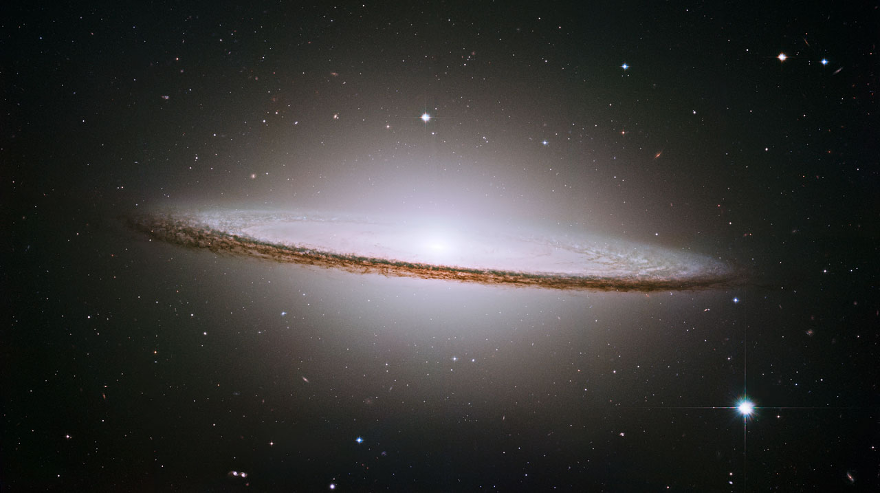 NASA/ESA Hubble Space Telescope has trained its razor-sharp eye on one of the universe's most stately and photogenic galaxies, the Sombrero galaxy, Messier 104 (M104). The galaxy's hallmark is a brilliant white, bulbous core encircled by the thick dust lanes comprising the spiral structure of the galaxy. As seen from Earth, the galaxy is tilted nearly edge-on. We view it from just six degrees north of its equatorial plane. This brilliant galaxy was named the Sombrero because of its resemblance to the broad rim and high-topped Mexican hat. At a relatively bright magnitude of +8, M104 is just beyond the limit of naked-eye visibility and is easily seen through small telescopes. The Sombrero lies at the southern edge of the rich Virgo cluster of galaxies and is one of the most massive objects in that group, equivalent to 800 billion suns. The galaxy is 50,000 light-years across and is located 28 million light-years from Earth.
