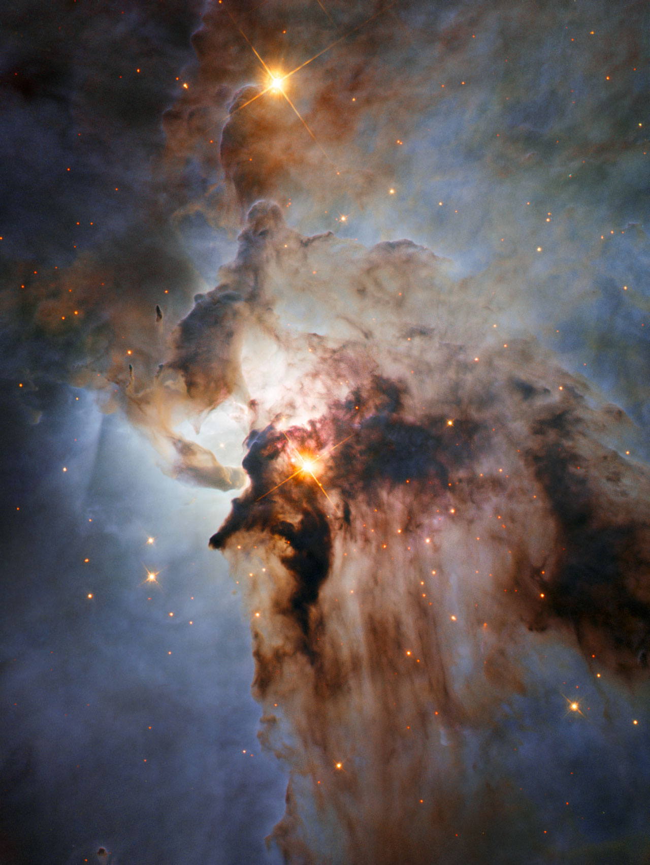 This new NASA/ESA Hubble Space Telescope image shows the Lagoon Nebula, an object with a deceptively tranquil name. The region is filled with intense winds from hot stars, churning funnels of gas, and energetic star formation, all embedded within an intricate haze of gas and pitch-dark dust.