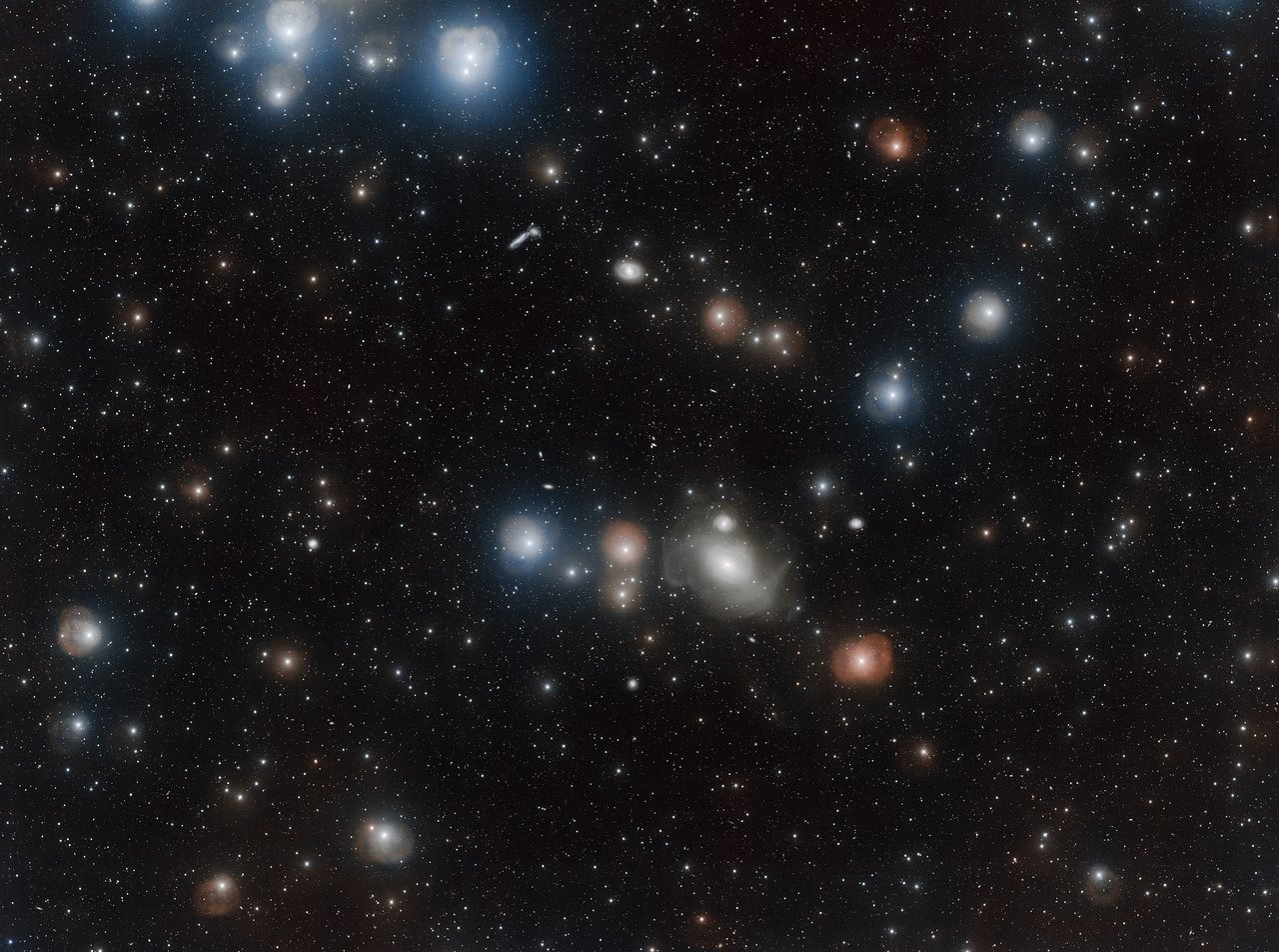 Countless galaxies vie for attention in this dazzling image of the Fornax Cluster, some appearing only as pinpricks of light while others dominate the foreground. One of these is the lenticular galaxy NGC 1316. The turbulent past of this much-studied galaxy has left it with a delicate structure of loops, arcs and rings that astronomers have now imaged in greater detail than ever before with the VLT Survey Telescope. This image was processed with the VST-Tube data reduction program.