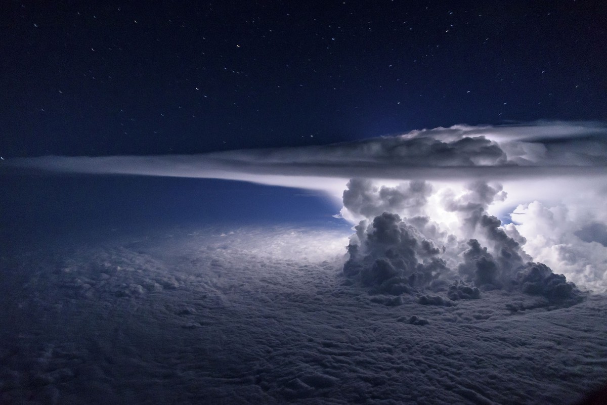A colossal Cumulonimbus flashes over the Pacific Ocean as we circle around it at 37000 feet  en route to South America